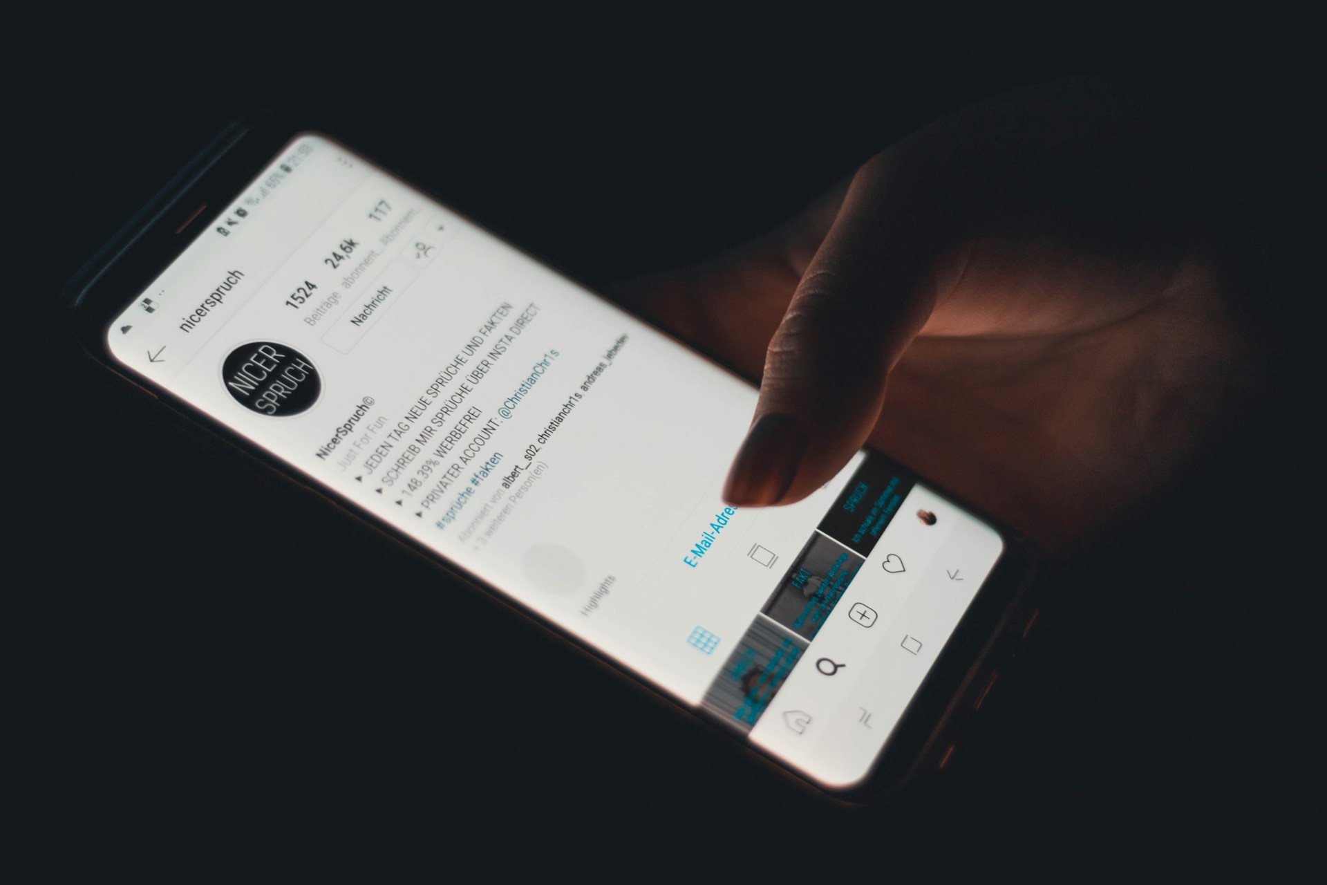 A person holding a smartphone showing an Instagram profile.