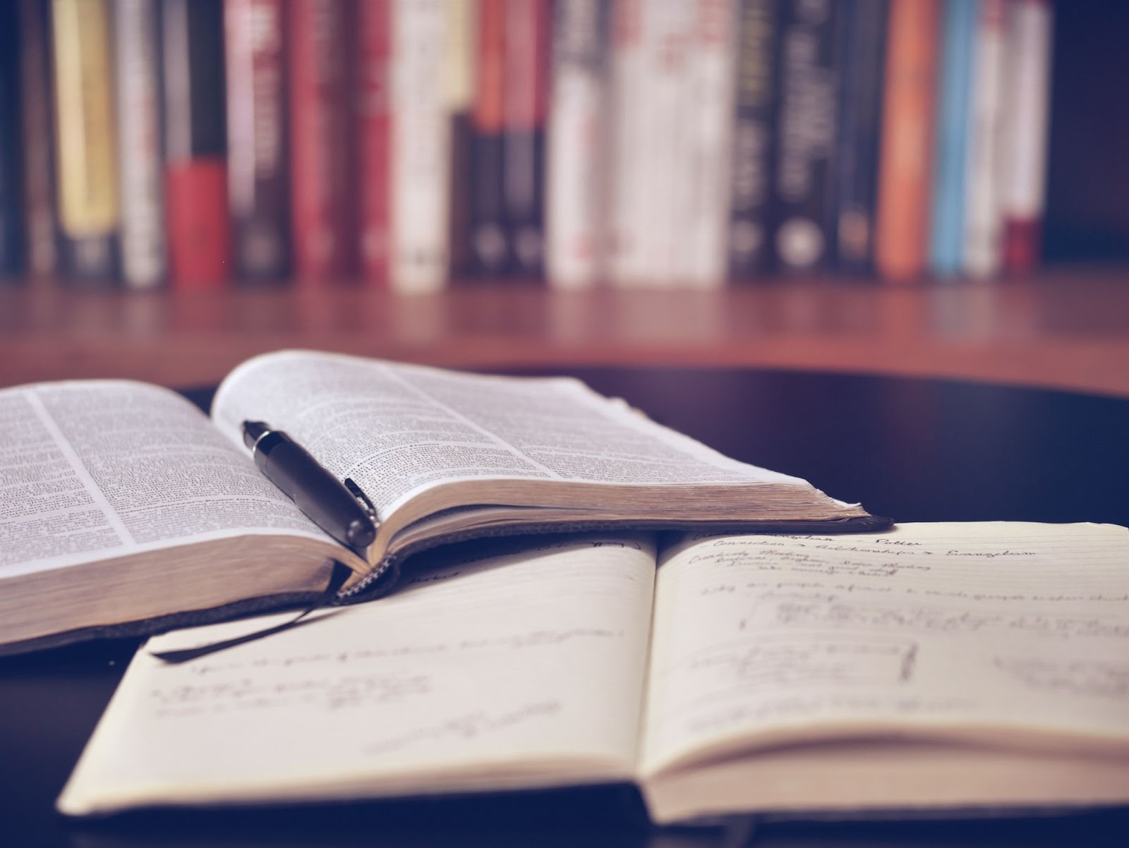 A stack of books with light shining on them, showcasing a publication with lines of fonts on book covers.