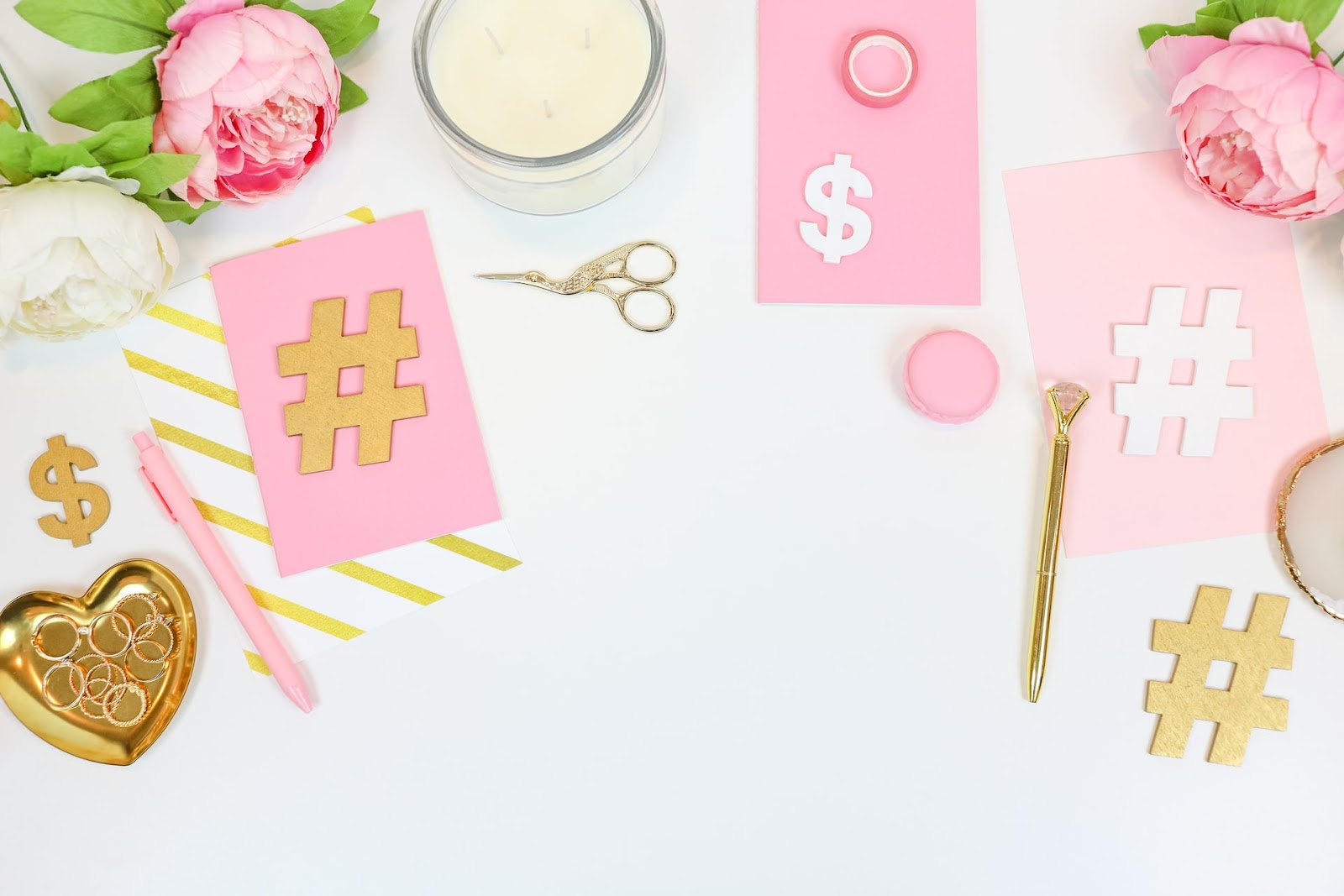 Pink dishware with flower petal design on a table with scissors and text "C $ C" in a stylish font.