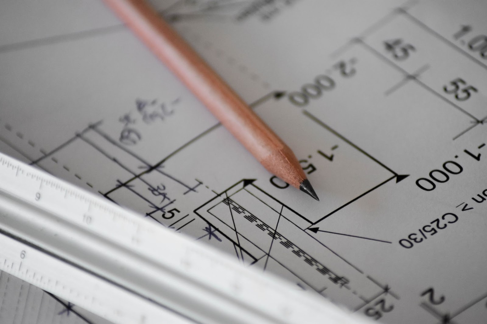 Office supplies on a desk with a pen, paper with handwritten text, and a cup of coffee.