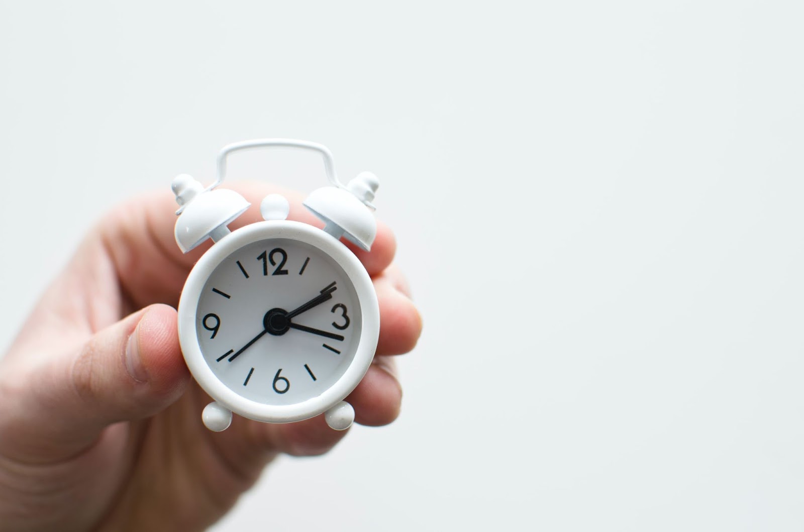 Hand pointing at a clock displaying 12/19 with text "This Month" - encouraging timely engagement on social media posts.