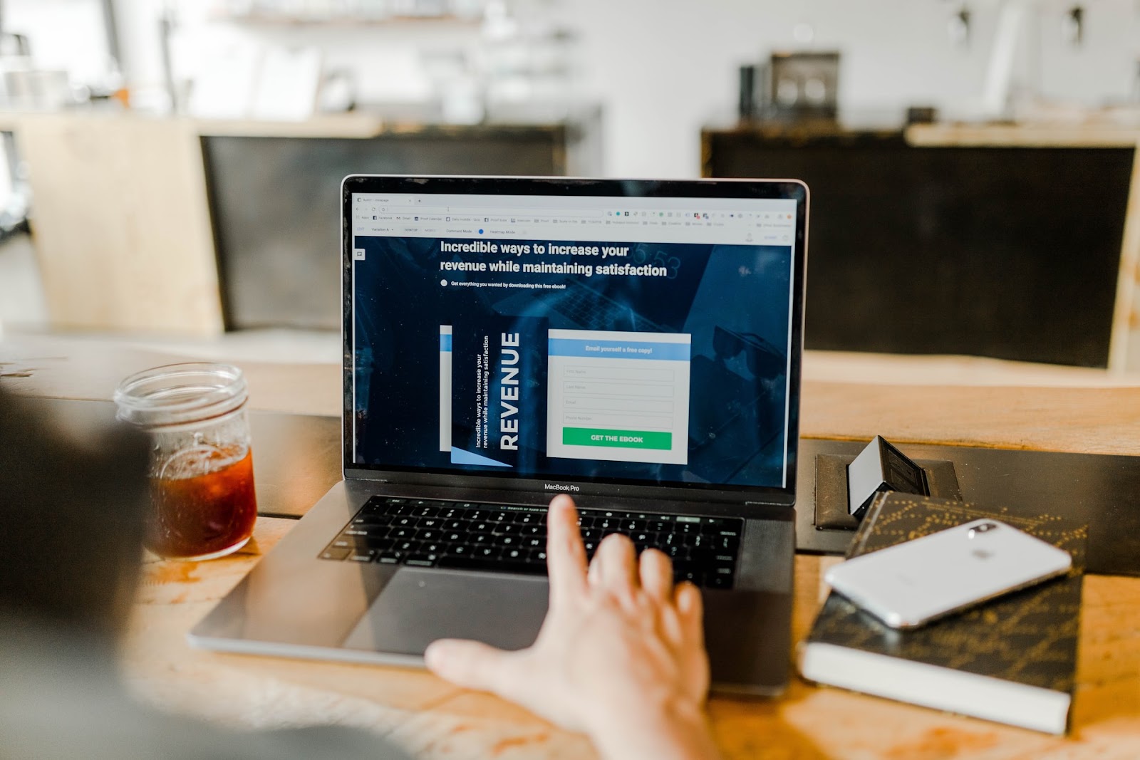 Computer and laptop on a table with tableware, a drink, computer keyboard, and the text "Incredible ways to increase your revenue while maintaining satisfaction"