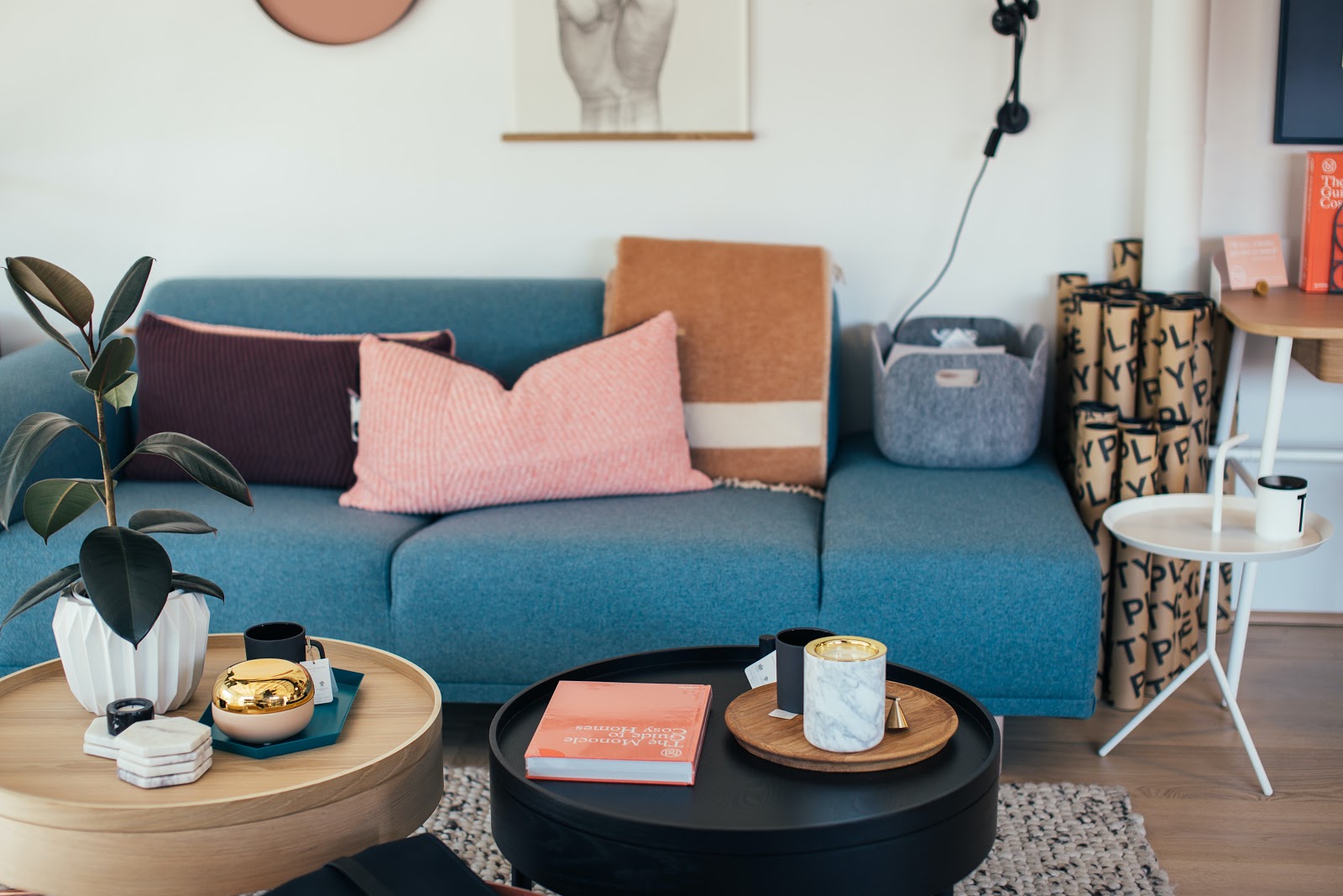 Table with green throw pillows, couch with picture frame, television and coffee table, displaying a piece of paper with text "ELAL YPOLPLAYEYPsotto Aso Spins PHY TPPThe Gu Co."