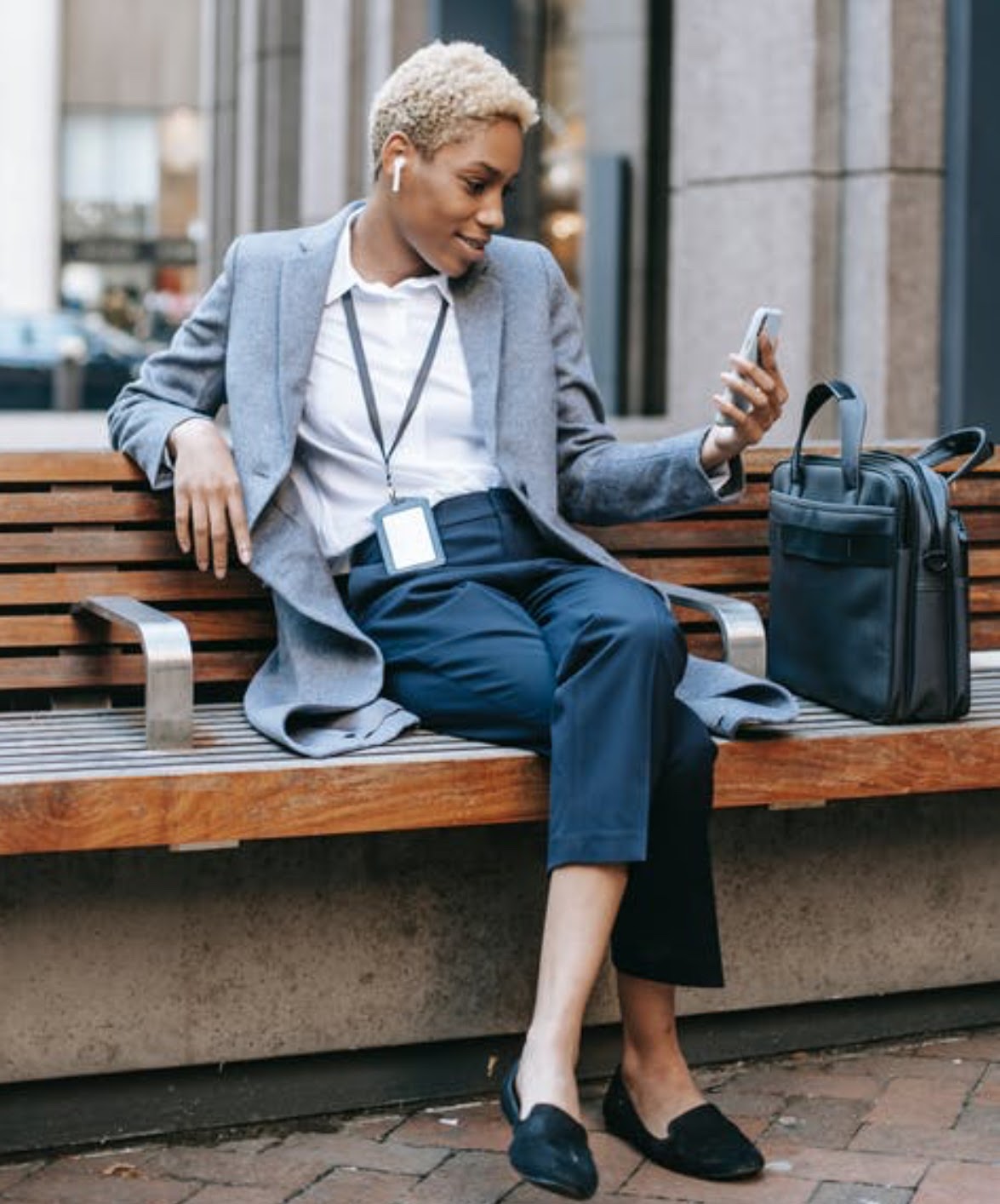 Person wearing stylish clothing, pants, coat, and shoes, with a trendy hairstyle, in a photograph focusing on the leg and shoes.