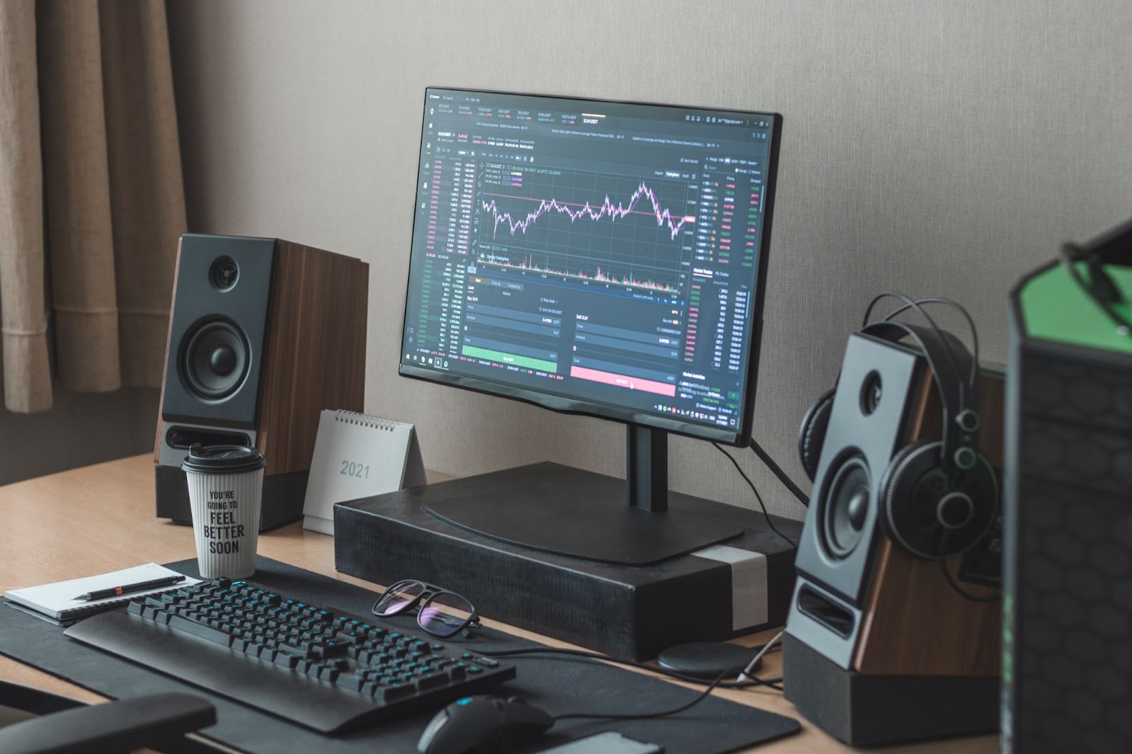 Computer with monitor, keyboard, mouse, and speakers on a desk displaying text "YOU'RE GOING TO FEEL BETTER SOON 2021"