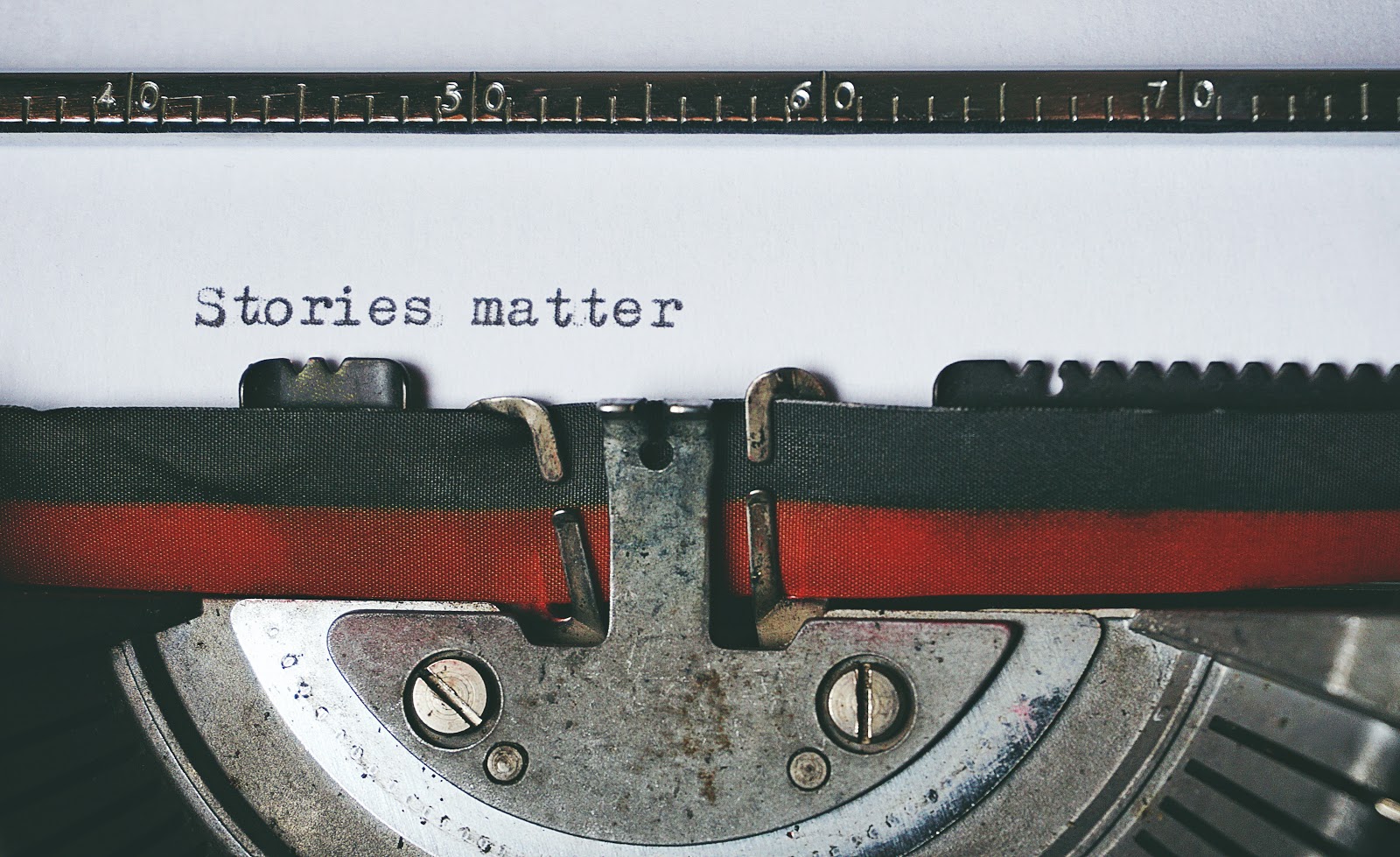 Hood of a car with front bumper, tire, and belt, showcasing automotive lighting. Text overlay reads: "Stories matter".